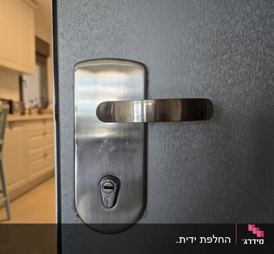 ידית דלת ומנעול מתכת בכניסה לבית